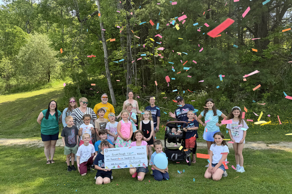 Students, staff and volunteer with the $1600 check