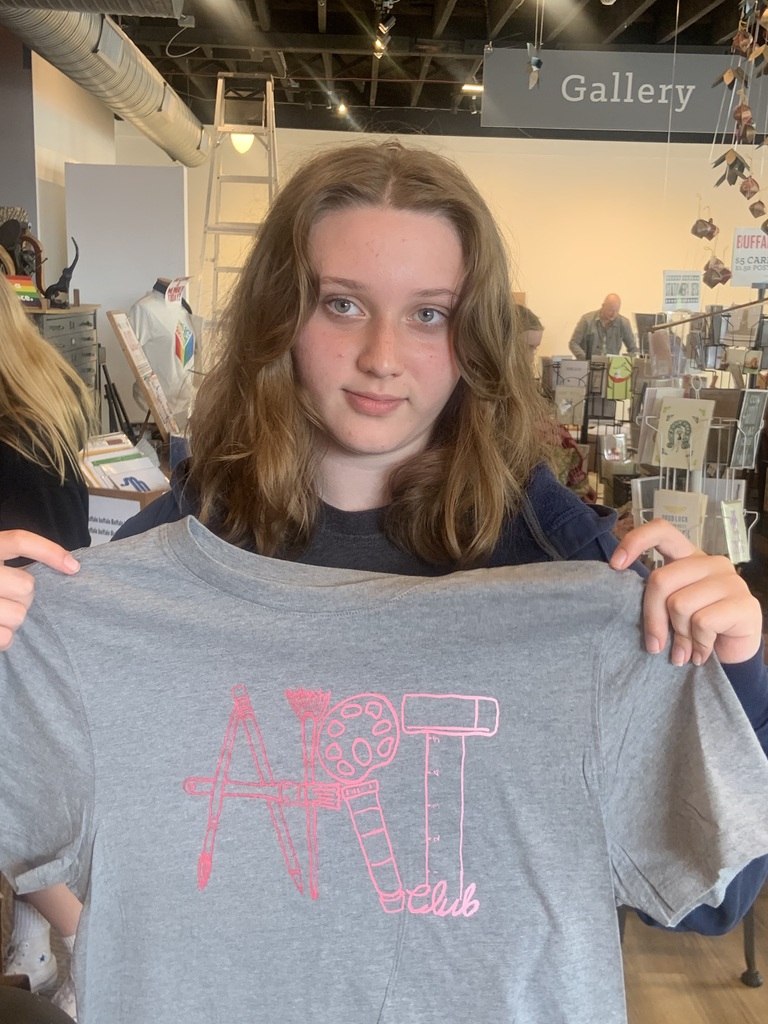 A student holds up her T-shirt.