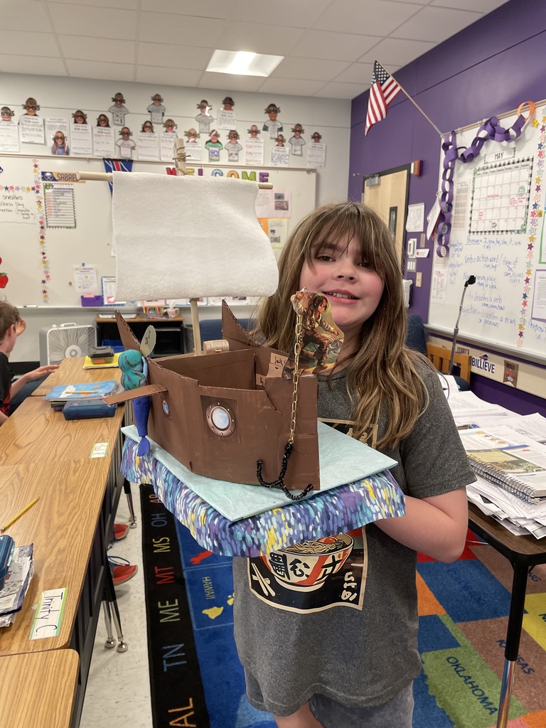 A student holds a float in the shape of a boat.