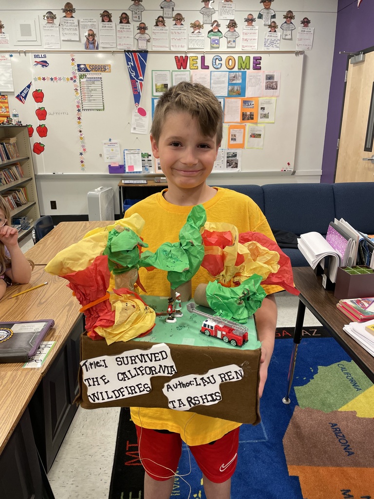 A student holds a float representing a wildfire.