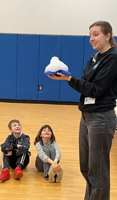 An instructor holds snow. 