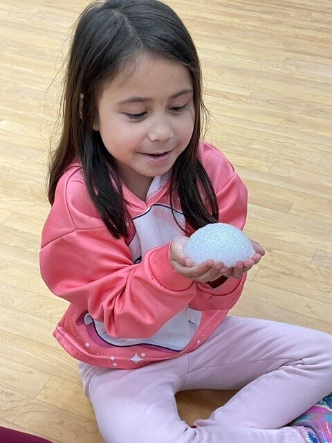 a student holds snow. 