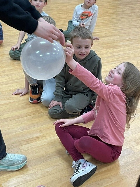 A student holds a balloon. 