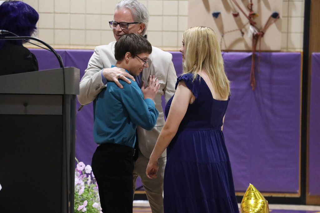 Student hug Mr. Beiter, who is retiring. 