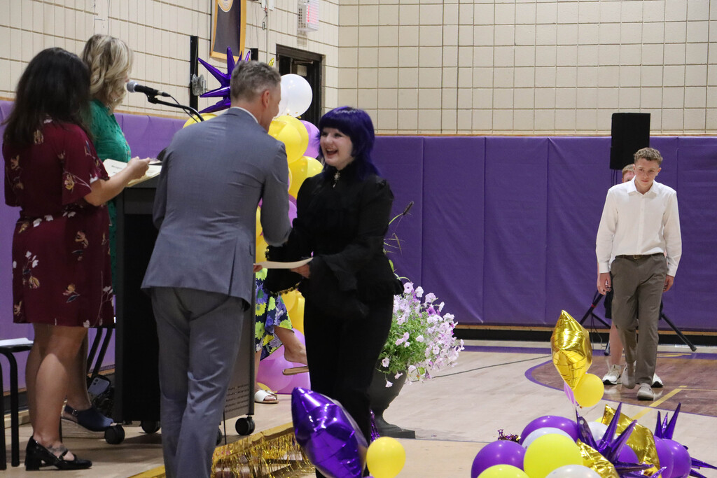 Student accepts their certificate. 