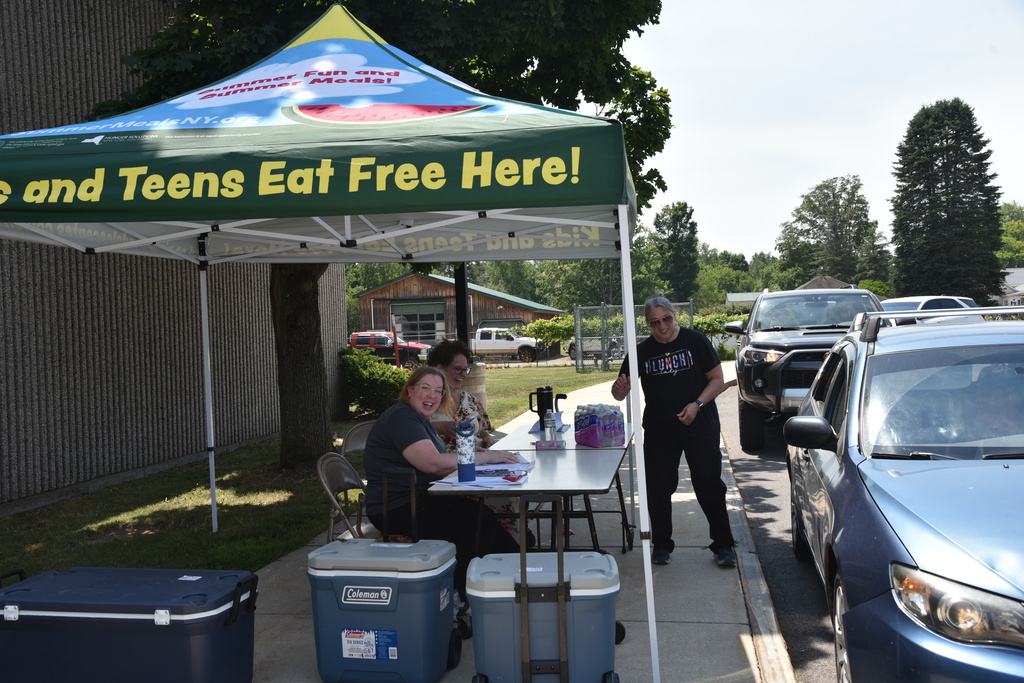 Culinary staff greet cars.