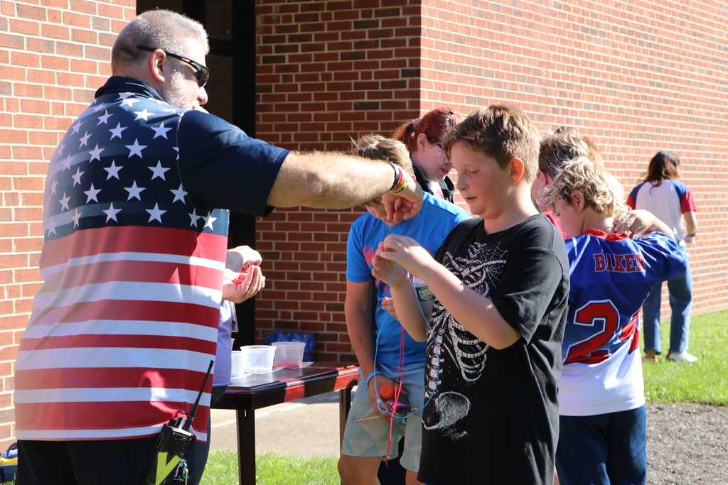 Mr. V gives a student a bead 