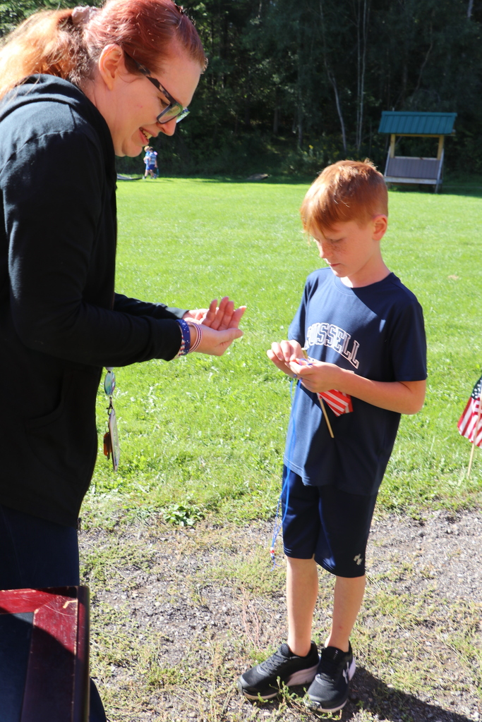 A student receives a bead from a teacher 