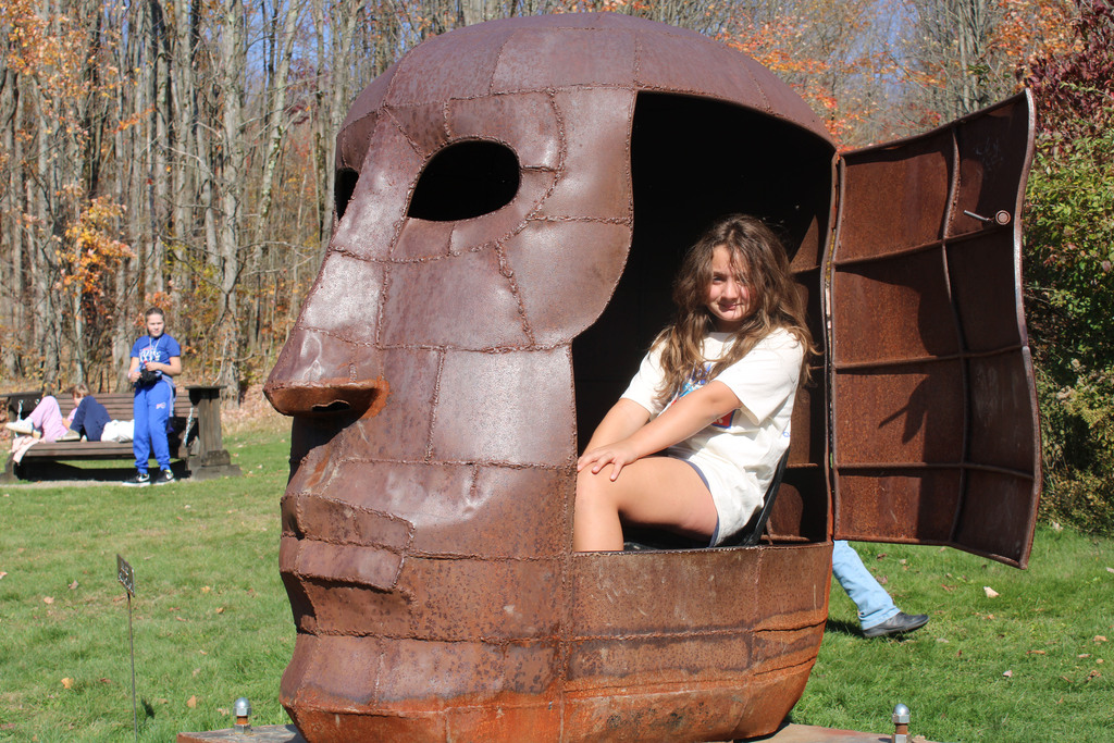 Student inside sculpture of a head