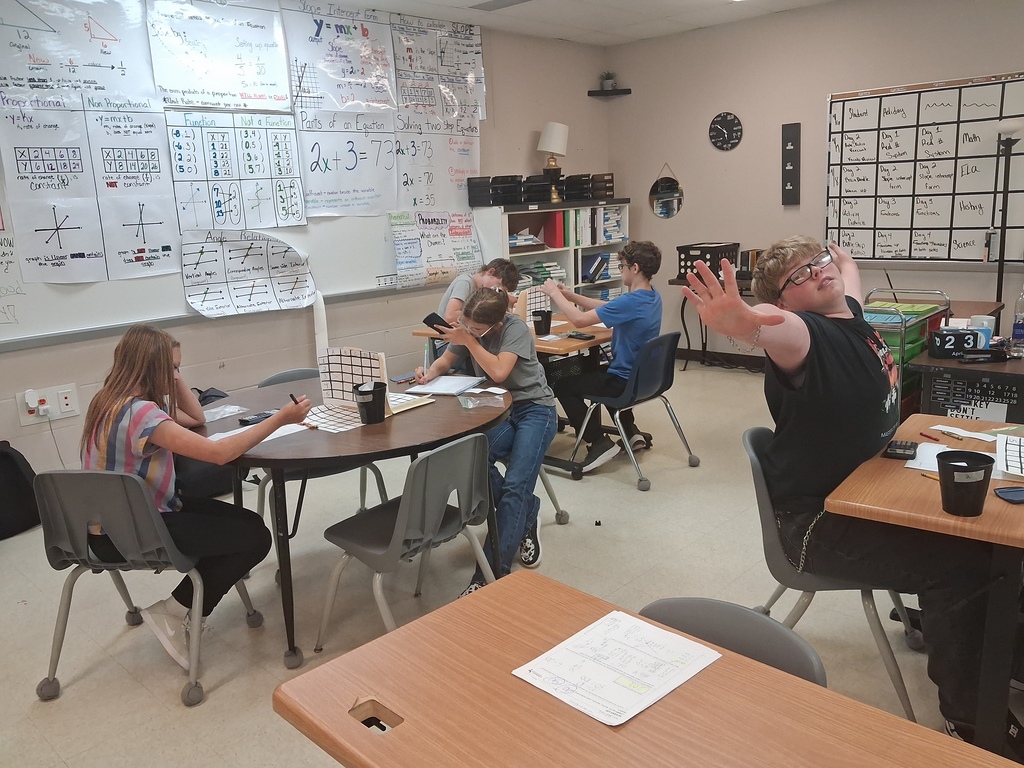 math squd battle ship game in action with paper and squares instead of the real battleship game, boy with arm raised like a stop sign