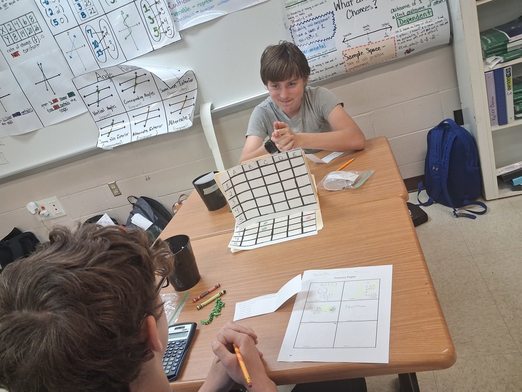 math squd battle ship game in action with paper and squares instead of the real battleship game, boy smiling