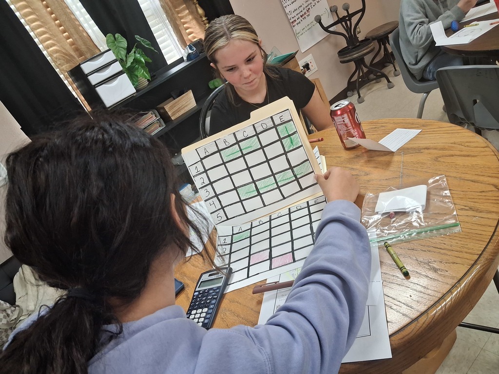 math squd battle ship game in action with paper and squares instead of the real battleship game, girl focused