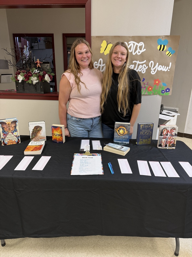 2 happy students in front of ffa table