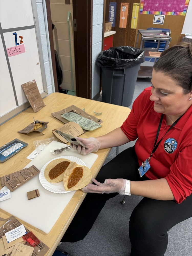 Ms Deana making our beef Taco MRE with applesauce, cheese cracker and blue juice!