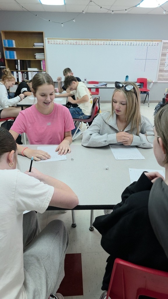 Middle school students work on critical thinking skills in math with a dice game. 