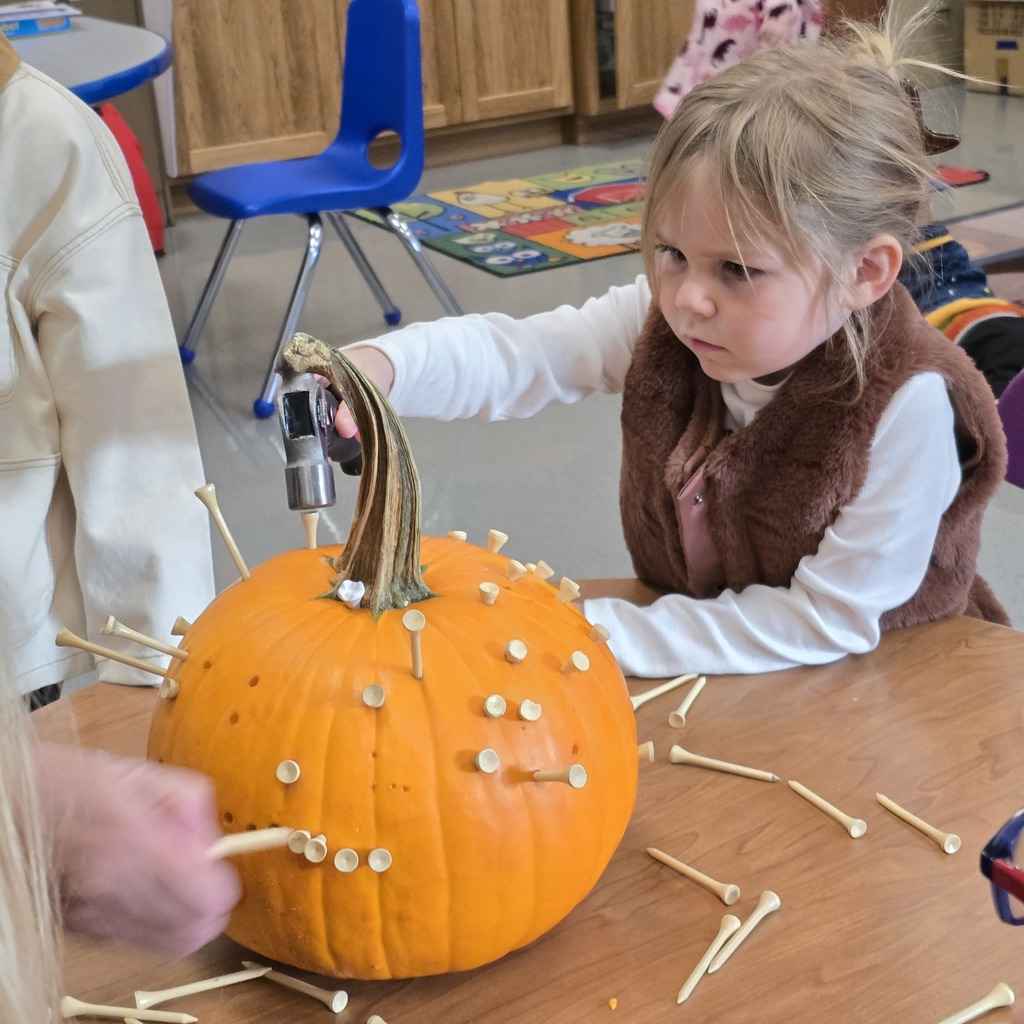 Tiger Cubs student hammer pumpkins to work on hand-eye coordination. 