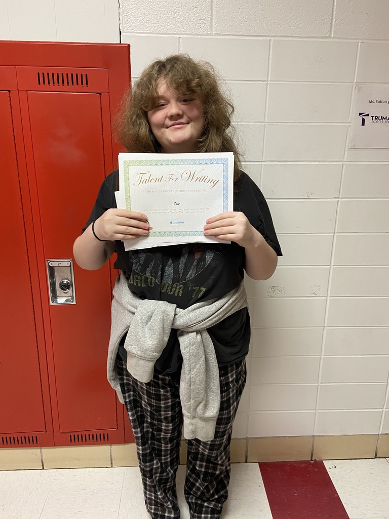 Tiger published in young writers anthology poses in hallway with certficiate! 