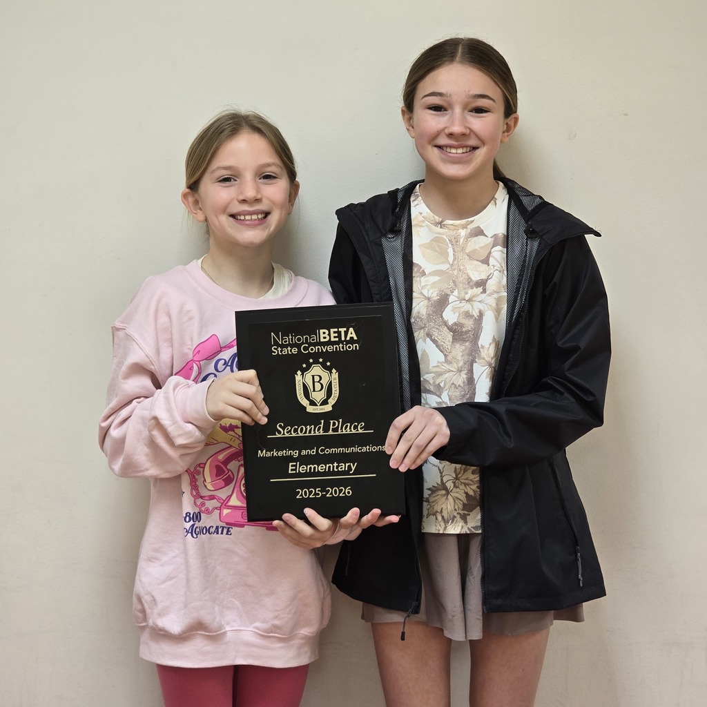 Two girls standing and holding a plaque that says "Second Place Marketing and Communications Elementary 2017-2018".