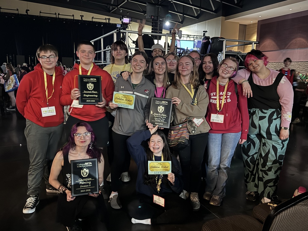 A group of people wearing IDs pose for a photo with certificates at a school event.
