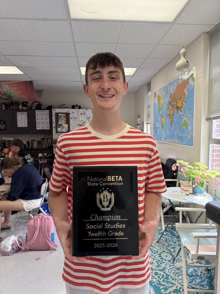 A person in a red-and-white striped shirt holds a plaque that reads "National BETA Champion Social Studies Twelfth Grade 2023-2024."