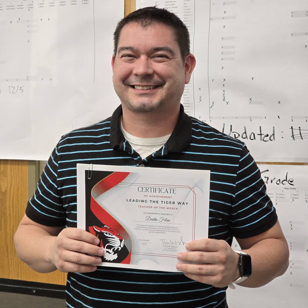 Man holding a certificate with red and black design, smiling. He wears a blue-and-white striped polo.