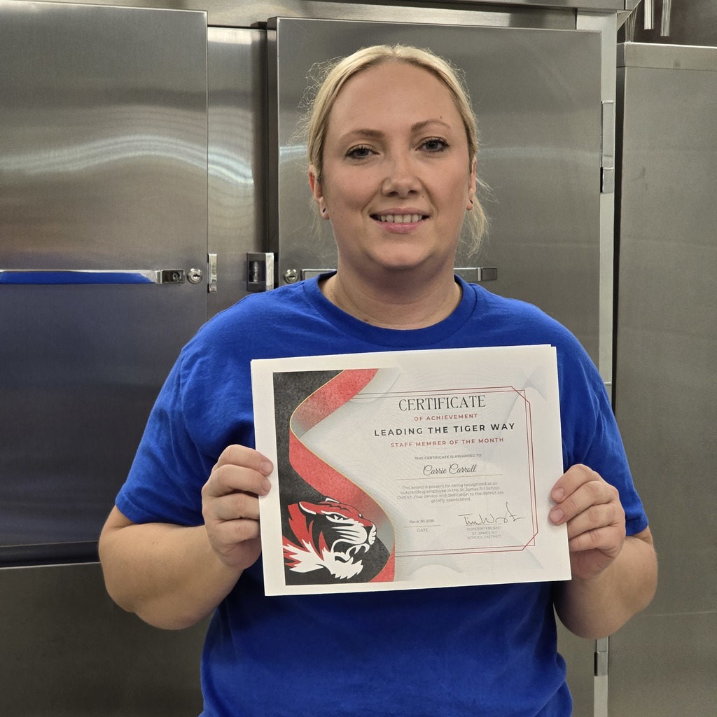 Woman in a blue shirt holding a certificate with a red ribbon and logo.