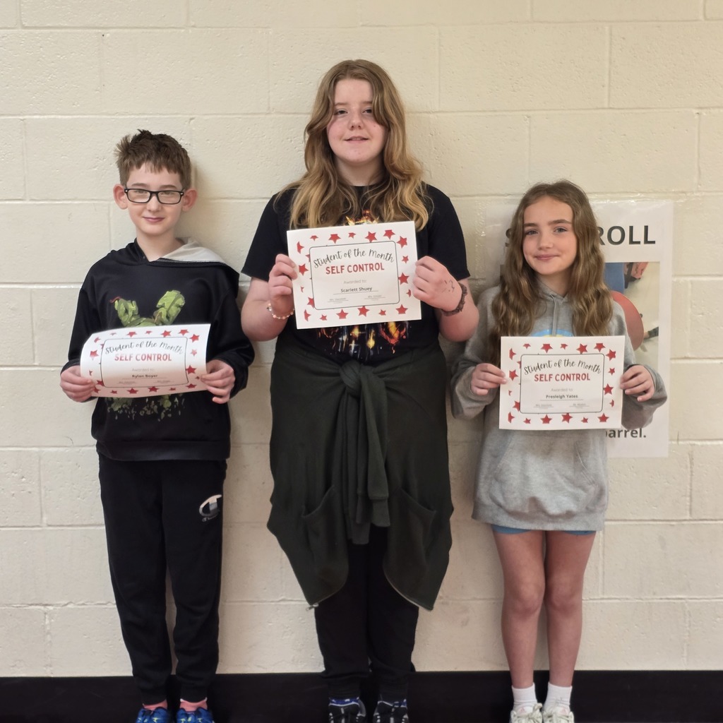Three children stand together, each holding a certificate. One holds it in both hands.