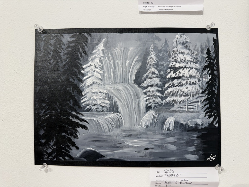 Black-and-white painting of a waterfall with snow-covered trees and rocks in the foreground, displayed on a wall.