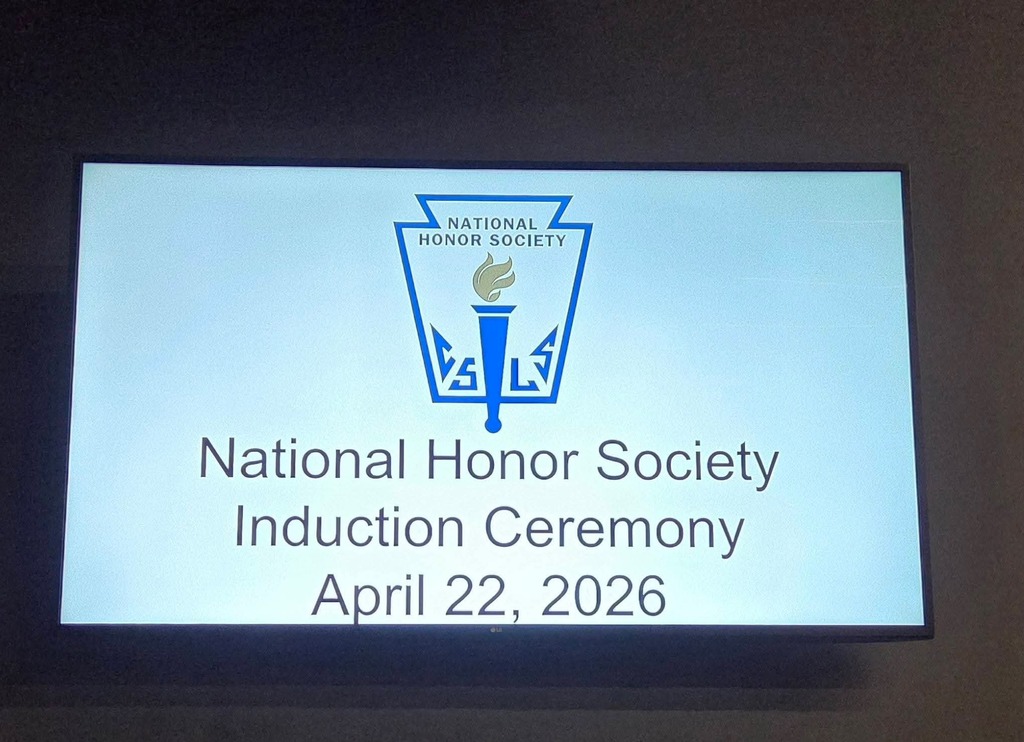 A screen shows "National Honor Society Induction Ceremony April 22, 2026" with an emblem above the text.