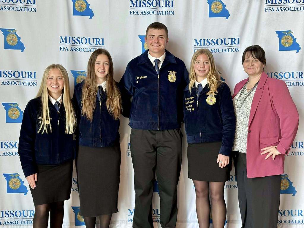 Five individuals stand in front of a backdrop with "Missouri" and "FPA Association" written on it. Four of them are in matching jackets.