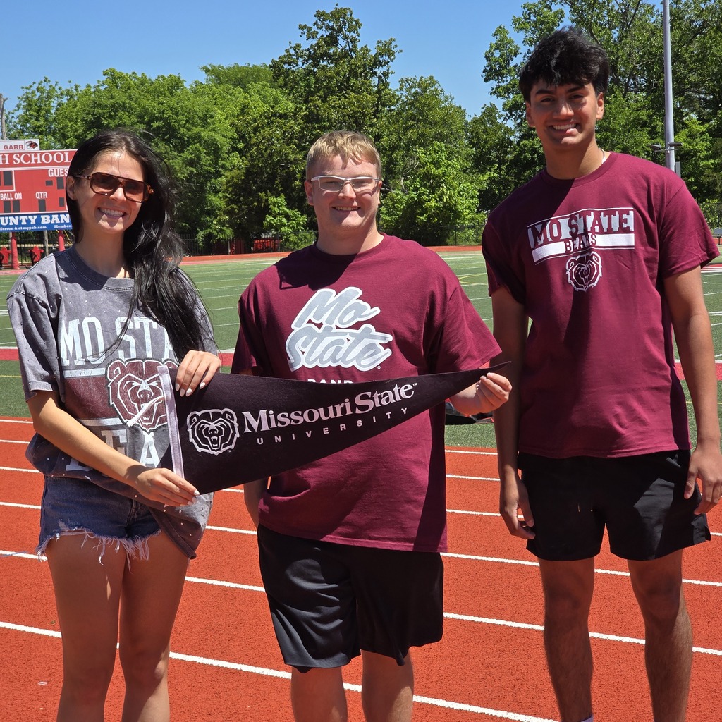 Three people stand on a running track, holding a banner with "Missouri State" written on it.