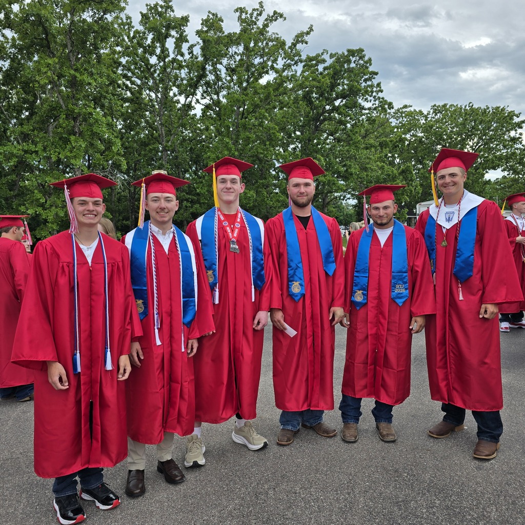 Five men in red caps and gowns stand in a row, possibly at a graduation. Behind them are trees and a cloudy sky.
