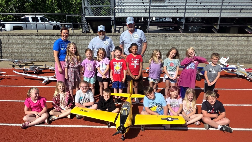 Zoom with second grade. Students pose with RC Plane. 