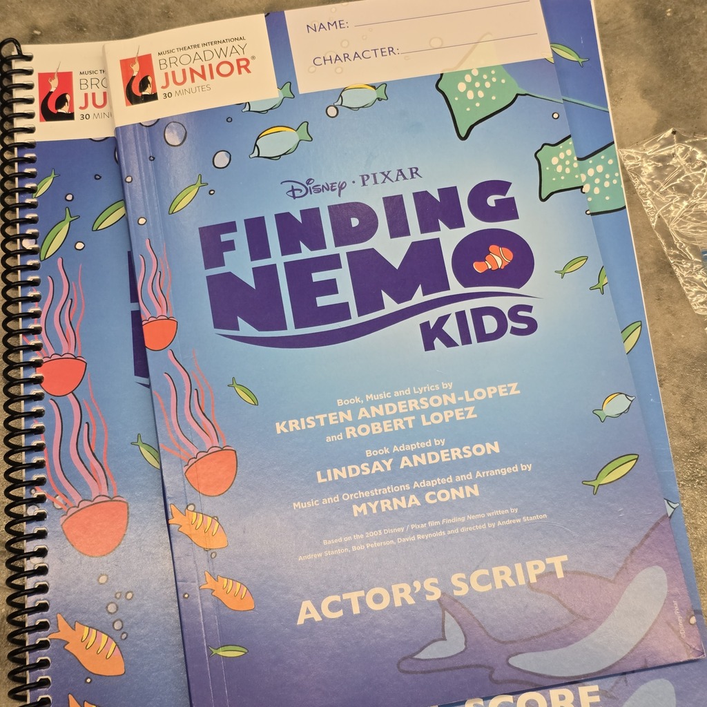 Two spiral-bound books titled "Finding Nemo Kids" with images of fish and sea creatures. The cover shows names of actors and script details.