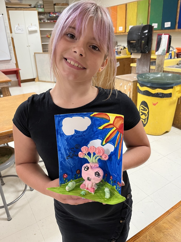 Girl with pink hair displays artwork, showing a pink character with flowers and a sun.