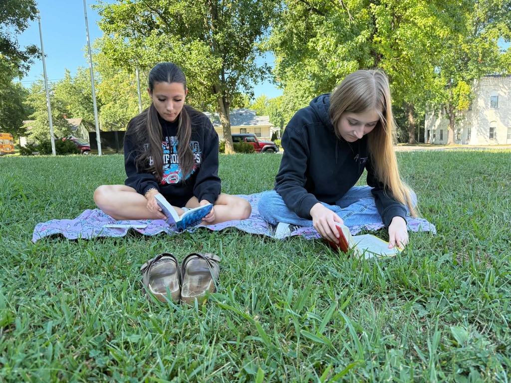 Great Books class reads outside.