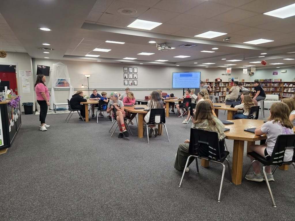 Students listen to Mrs. McCurdy's lesson in the library. 