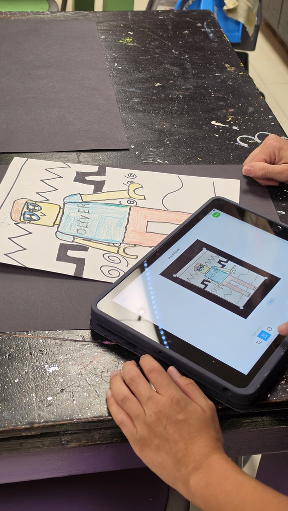 Students take photographs of their artwork to upload into Artsonia, the digital art gallery.