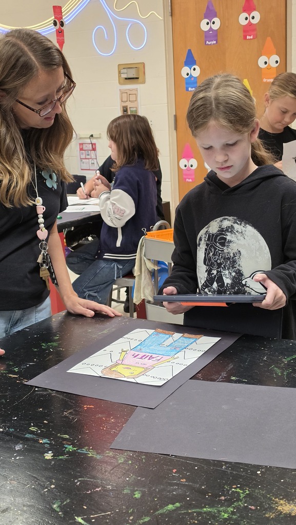 Students take photographs of their artwork to upload into Artsonia, the digital art gallery.