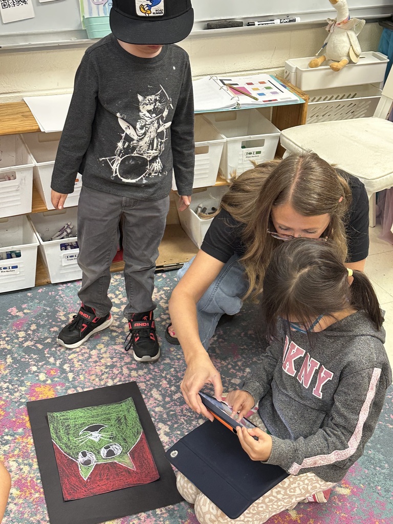 Students take photographs of their artwork to upload into Artsonia, the digital art gallery.