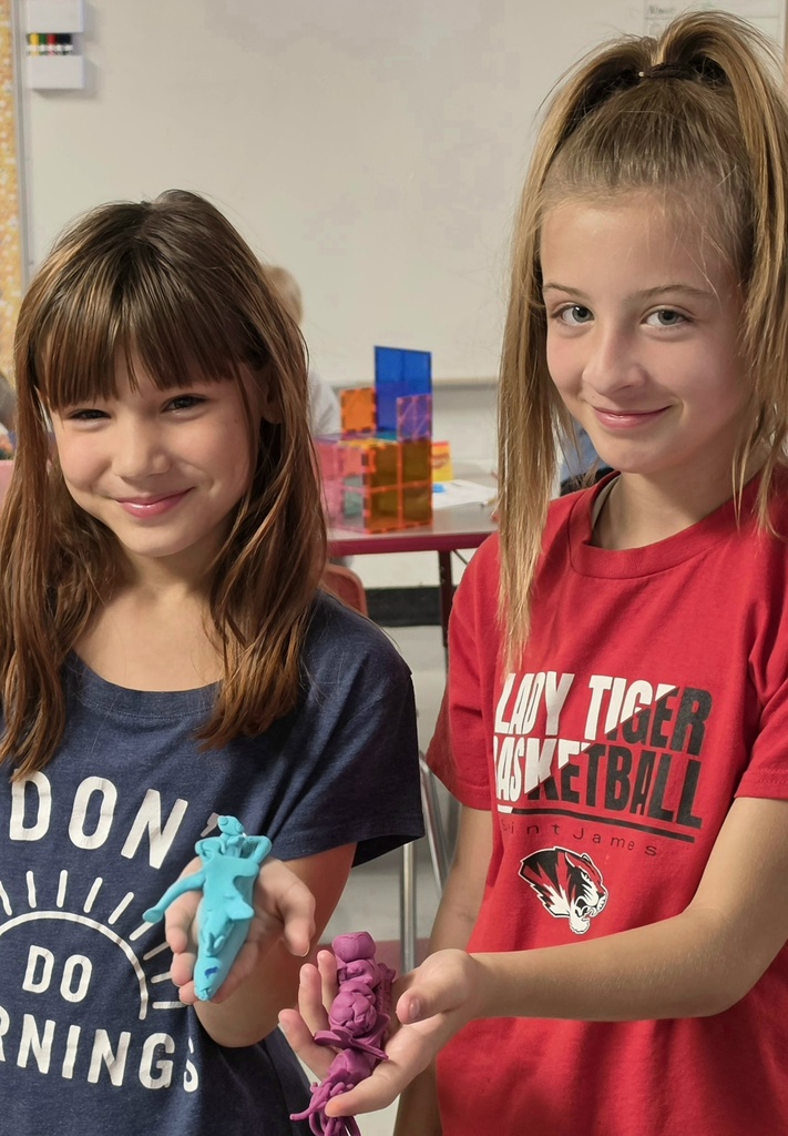 Fifth-grade students help kindergarten students build their own brooms during a Halloween-themed STEM challenge after reading Room on the Broom.