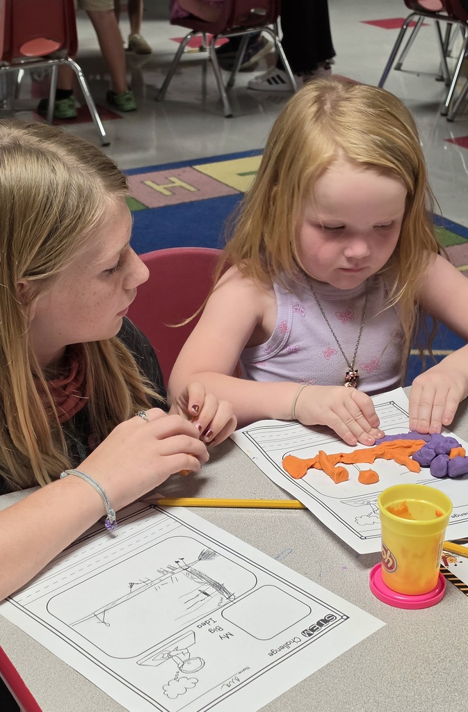 Fifth-grade students help kindergarten students build their own brooms during a Halloween-themed STEM challenge after reading Room on the Broom.