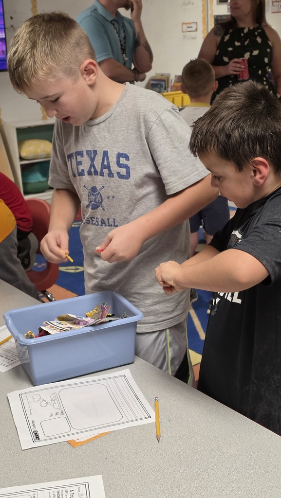 Fifth-grade students help kindergarten students build their own brooms during a Halloween-themed STEM challenge after reading Room on the Broom.