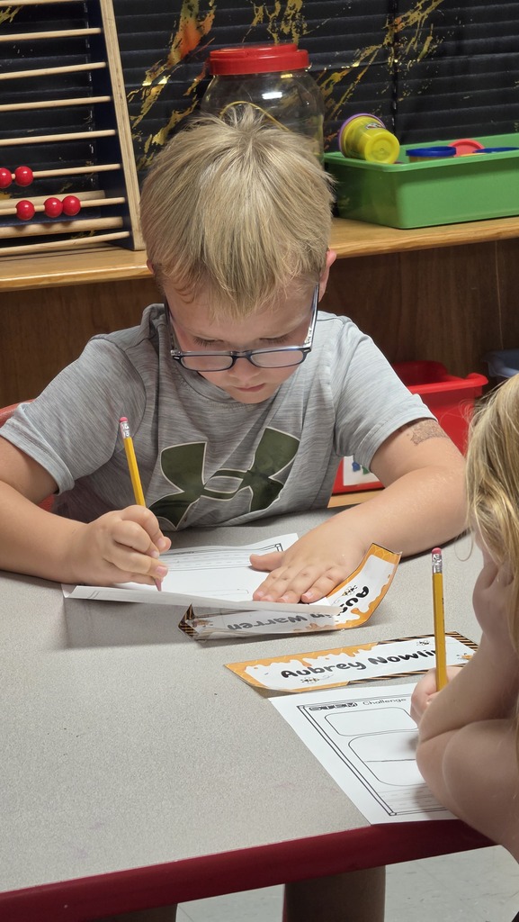 Fifth-grade students help kindergarten students build their own brooms during a Halloween-themed STEM challenge after reading Room on the Broom.