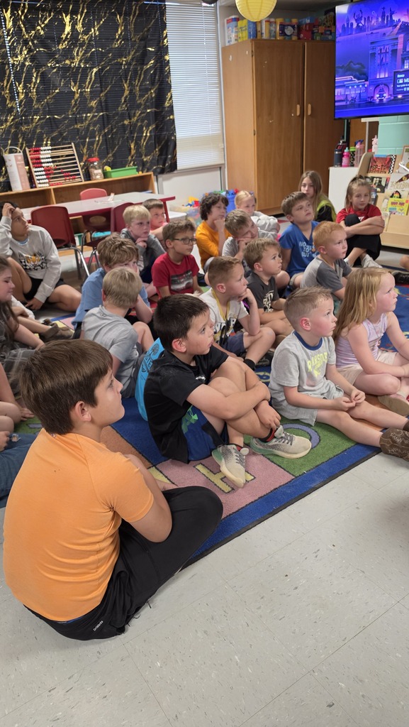 Fifth-grade students help kindergarten students build their own brooms during a Halloween-themed STEM challenge after reading Room on the Broom.