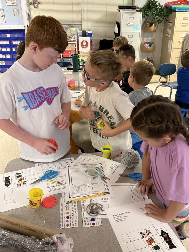 Fifth-grade students help kindergarten students build their own brooms during a Halloween-themed STEM challenge after reading Room on the Broom.