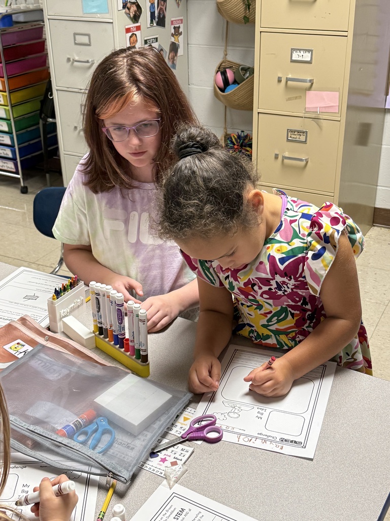 Fifth-grade students help kindergarten students build their own brooms during a Halloween-themed STEM challenge after reading Room on the Broom.