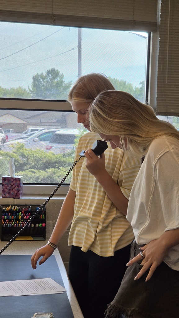 Students read the daily announcements at St. James high school.