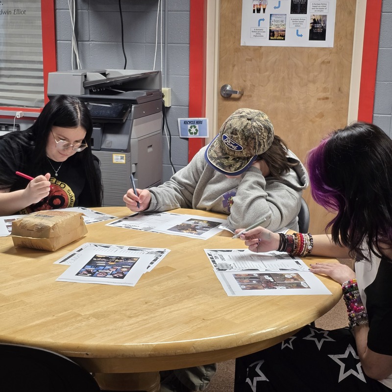 Critical Thinking students sit at table analyzing graphic novel structures.