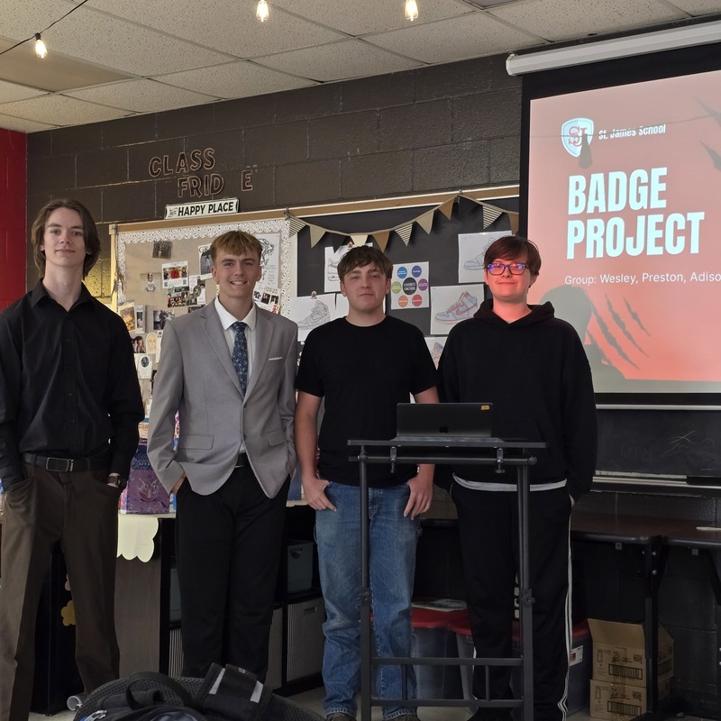 Students stand at front of classroom in front of board to give presentation! 